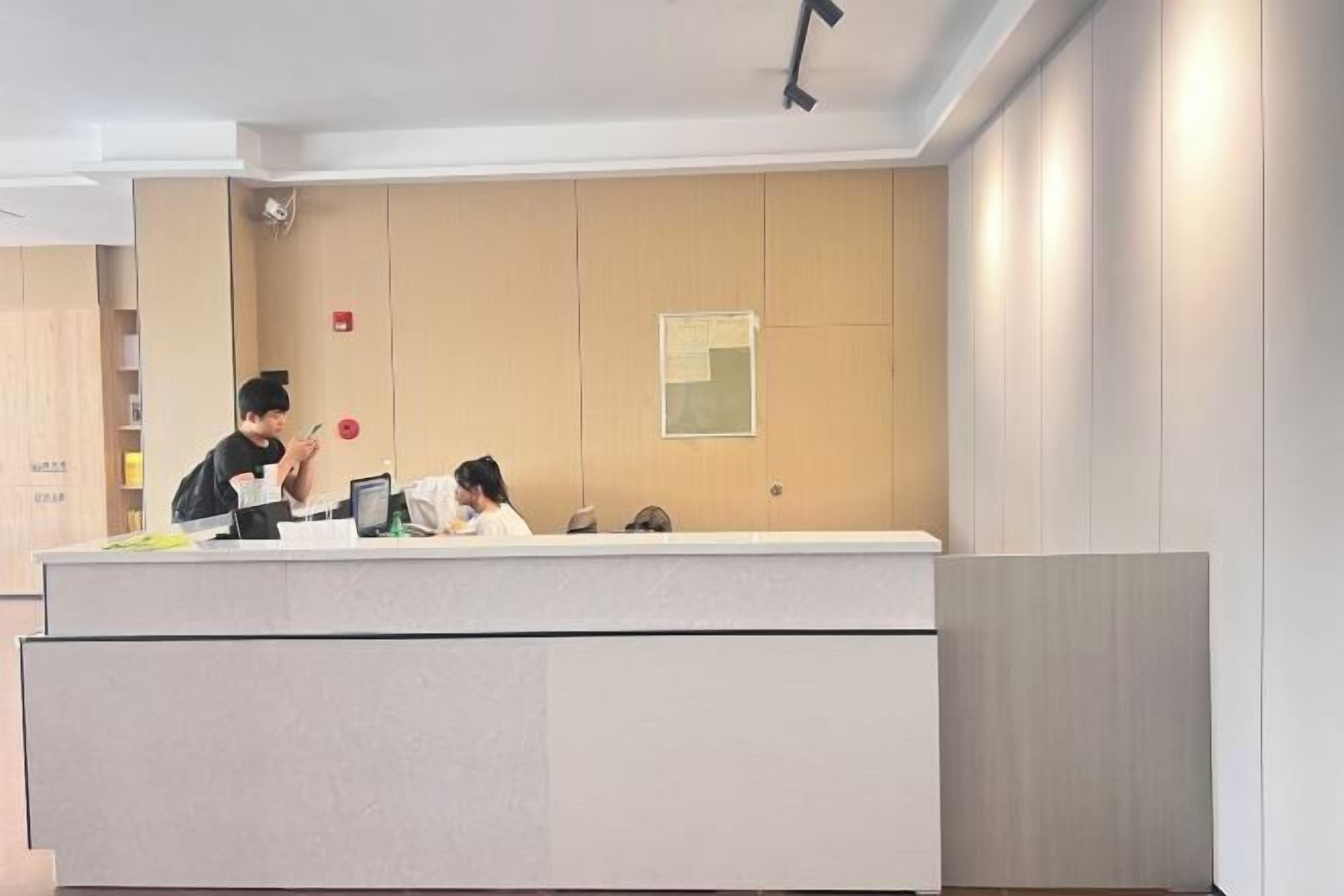 A reception desk with a counter, a security camera, and a bulletin board on the wall.