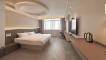 A modern hotel room with a large bed, a desk, and a flat-screen TV.