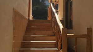 A wooden staircase with a wooden handrail leading to an open doorway. - Moganshan Xiyuan Inn (Deqing)