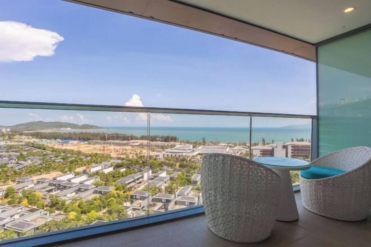 Un balcon donnant sur la côte, deux fauteuils en osier et une petite table ronde.