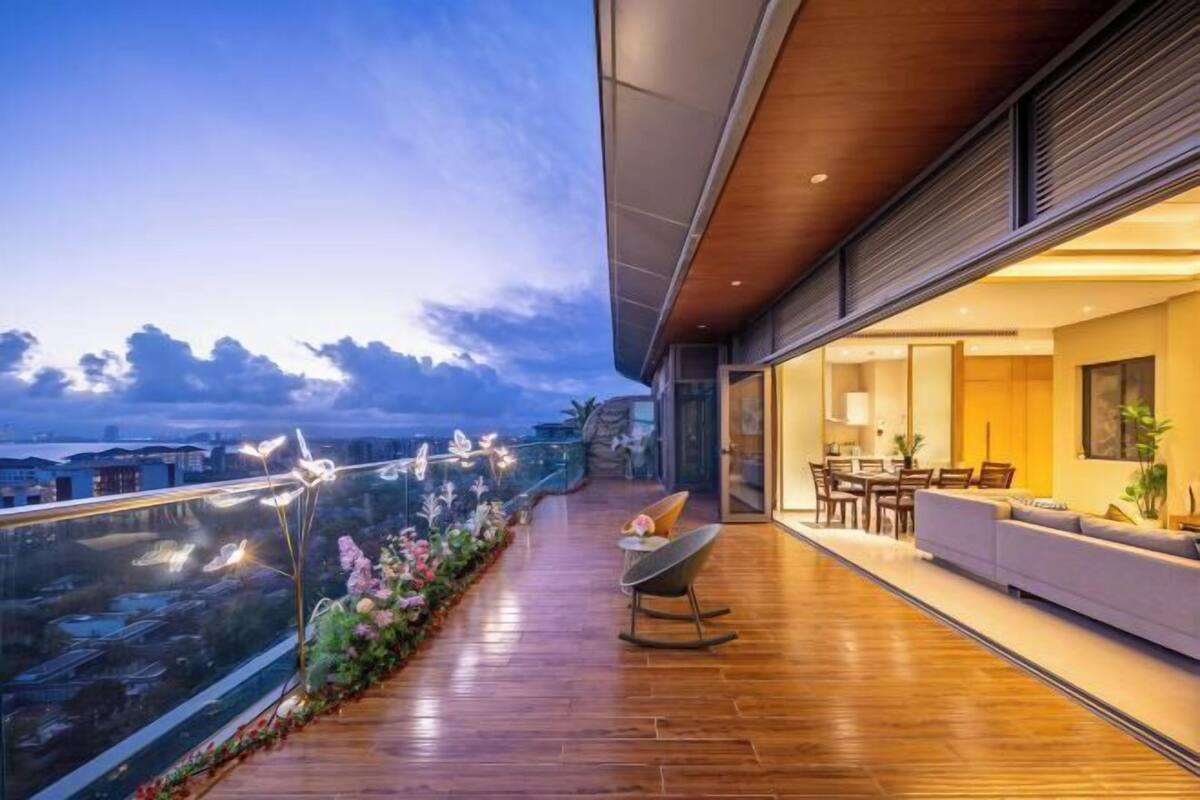 Un balcon moderne avec un plancher en bois, un coin repas comprenant une table et des chaises, et un canapé.