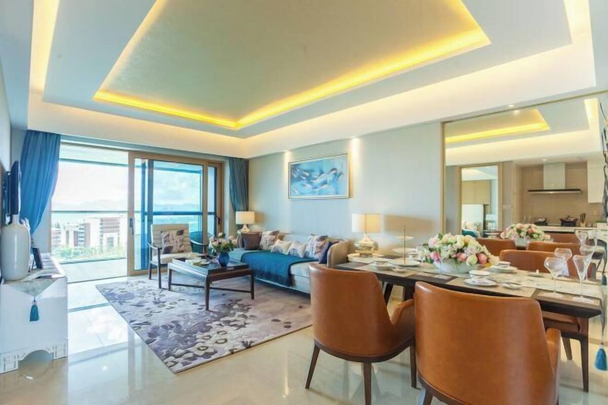 Un salon moderne avec un canapé, une table basse et un coin repas comprenant des chaises et une table mise pour le repas.