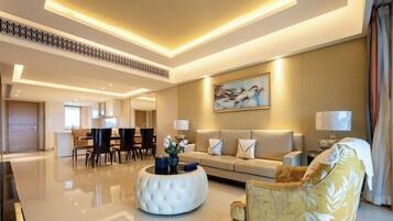 A modern hotel lobby with a central seating area, a dining space, and a sofa set.