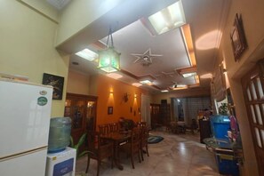 A spacious kitchen with a dining area, a ceiling fan, and a water dispenser. - Ish Atithya Corporate Serviced Apartments with Modular Kitchens in Lucknow, IN (Lucknow)