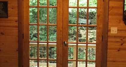 Cozy cabin in secluded forest with deck on creek. Full kitchen. 900 square feet.