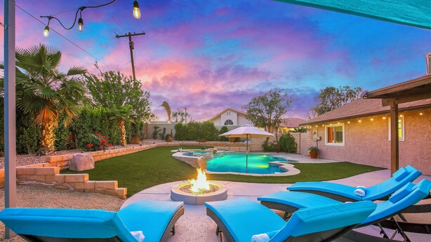 A backyard with a swimming pool, lounge chairs, and a fire pit. - Bermuda Palms: Pool, Spa, Arcade Game, Fire pit! (Bermuda Dunes)