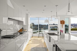 A modern kitchen with a large window, a view of the city, and a dining area with a view.