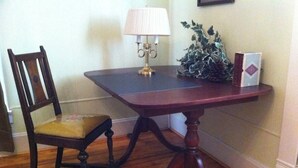 A wooden dining table with a lamp, a chair, and a decorative plant. - Charming 1-bedroom house in Historic Mineola, short walk to town (Mineola)