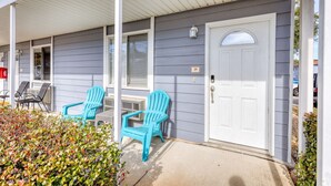 A house with a porch, two blue chairs, a white door, and a mailbox. - Walk to the Beach | 2 Pools | Military Welcome! (Biloxi)