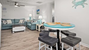 Un salon moderne avec une table ronde, deux canapés, une table basse et un ventilateur de plafond.