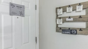 Une porte sur laquelle est affiché un panneau indiquant « Heure de silence », ainsi qu’un tableau d’affichage contenant divers messages et un panneau « Il est interdit de fumer ».