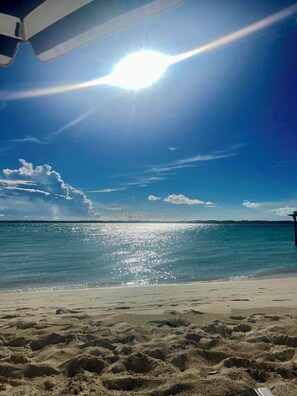 A beach with a clear sky, calm sea, and a sandy shore. - Luxury Exuma 2bdrm Apartment #1 - Beach access  (Exuma)
