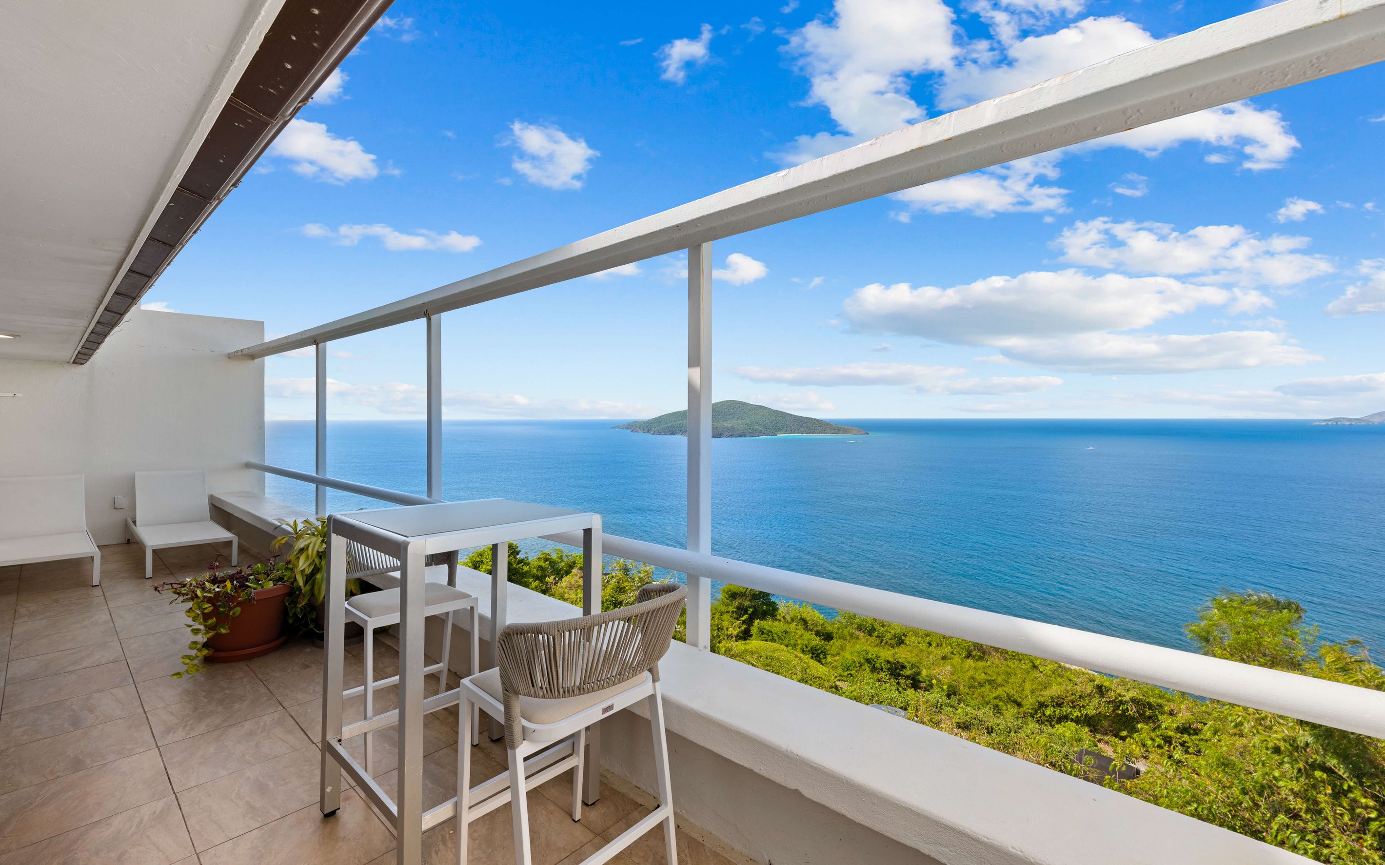 Een balkon met uitzicht op zee en een klein eiland.