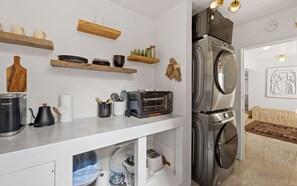 A compact kitchen with a coffee maker, toaster, and a built-in oven.