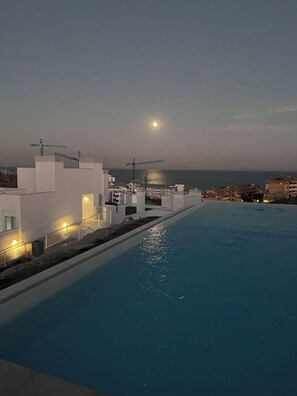 A swimming pool with a view of the sea and buildings in the background. - Luxurious 2-Bedroom Apartment; with Rooftop Pool, 10 mins to Beach (Fuengirola)
