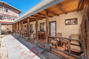 A covered outdoor seating area with stone pillars, wooden beams, and a tiled floor. - Beachside Studio Apartment with Pool and Free WiFi (Provincia de Guanacaste)