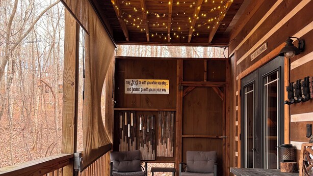 Una cabaña de madera con hidromasaje, terraza de madera y un cartel que dice “que el 30 de mayo te acompañe durante tu estancia… y la paz te acompañe de regreso”.