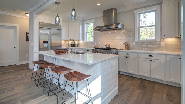A spacious kitchen with a large island, white cabinetry, and a stainless steel range hood. - Ocean-View Home- Chefs Kitchen,  Private Hot Tub, Dog Friendly, Double Patio (Pacific Beach)