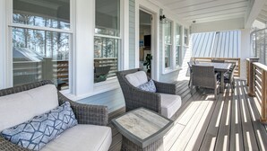 A covered porch with wicker furniture, a table, and a view of the surrounding area. - Ocean-View Home- Chefs Kitchen,  Private Hot Tub, Dog Friendly, Double Patio (Pacific Beach)