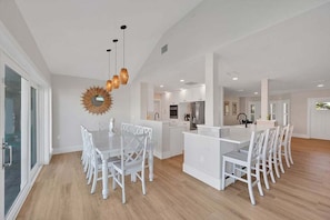 A modern kitchen with white cabinetry, a central island, and pendant lighting.