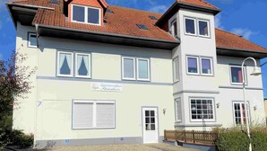 A two-story building with a sign indicating it is a residential property. - Strandnixe - A little time out - A little time out for relaxing days... Beach - and (Dahme)