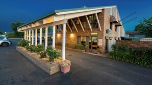 Un motel doté d’un parking couvert, d’un comptoir d’accueil et d’une façade en briques.