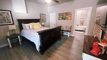 A bedroom with a bed, a nightstand, a dresser, and a ceiling fan.