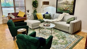 A living room with a sectional sofa, two armchairs, a coffee table, and a patterned rug. - Vacation home, < 1 mile to University of Notre Dame, walk, bike or drive! (South Bend)