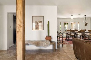 A living room with a bench, a cactus, and a framed picture on the wall. - Ember Stone • Hammock • Putting Green • Sleeps 10 (Yucca Valley)