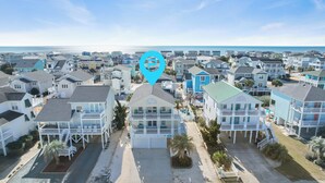 A beachfront residential area with multiple two-story houses featuring balconies and a view of the ocean.