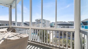 A covered outdoor area with a view of neighboring houses and a clear sky.