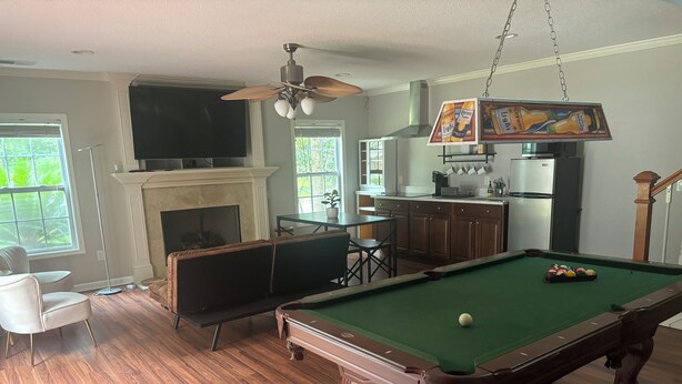 A living room with a pool table, a fireplace, a television, and a kitchen area. - Charming 1-bedroom apartment with WiFi, AC in enchanting Bluffton (Bluffton)