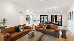 A modern living room with two leather sofas, a coffee table, and a ceiling fan. - Sunset Palms-Pool, Spa & Sports Court-Scottsdale (Scottsdale)