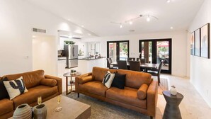 A modern living room with two sofas, a coffee table, and a dining area with a table and chairs. - Sunset Palms-Pool, Spa & Sports Court-Scottsdale (Scottsdale)