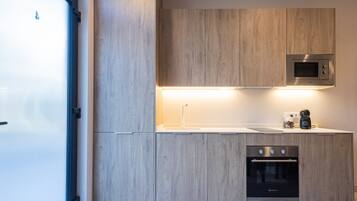 Een koelkast, een oven, een koffiezetapparaat/waterkoker, een waterkoker