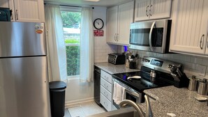 A modern kitchen with stainless steel appliances, granite countertops, and white cabinetry. - Waterfront Townhome- with Boat Slip and Dock! (Moneta)