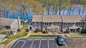 A multi-story building with a parking lot in front. - Waterfront Townhome- with Boat Slip and Dock! (Moneta)