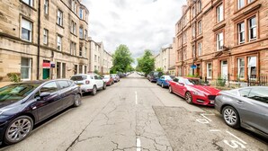A street lined with parked cars and buildings on both sides. - GuestReady - Comfortable 1Bed in Leith (Edinburgh)