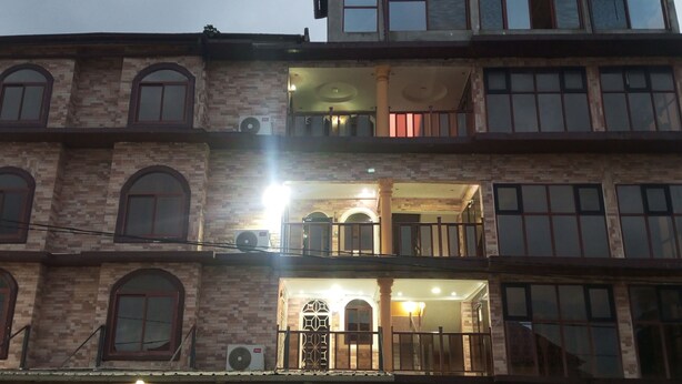 A multi-story building with a balcony on the second floor, large windows, and air conditioning units. - KalBock Apartment  (Monrovia)