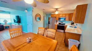 A compact kitchen with wooden cabinets, a microwave, a refrigerator, and a stove.
