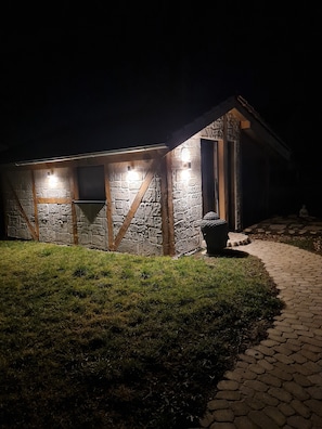 A stone building with a wooden door and windows, illuminated by exterior lights. - Apartment 'Nelly' with Wi-Fi (Bisingen)