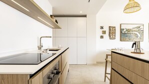 A modern kitchen with a central island, a built-in oven, and a hanging light fixture. - GuestHost - 68 sqm apartment for 2 people, featuring 3 balconies with a stunning sea view. Centrally located in Taormina, it offers the convenience of being close to all major attractions while remaining quiet and peaceful. Ideal for a couple seeking rel (Taormina)