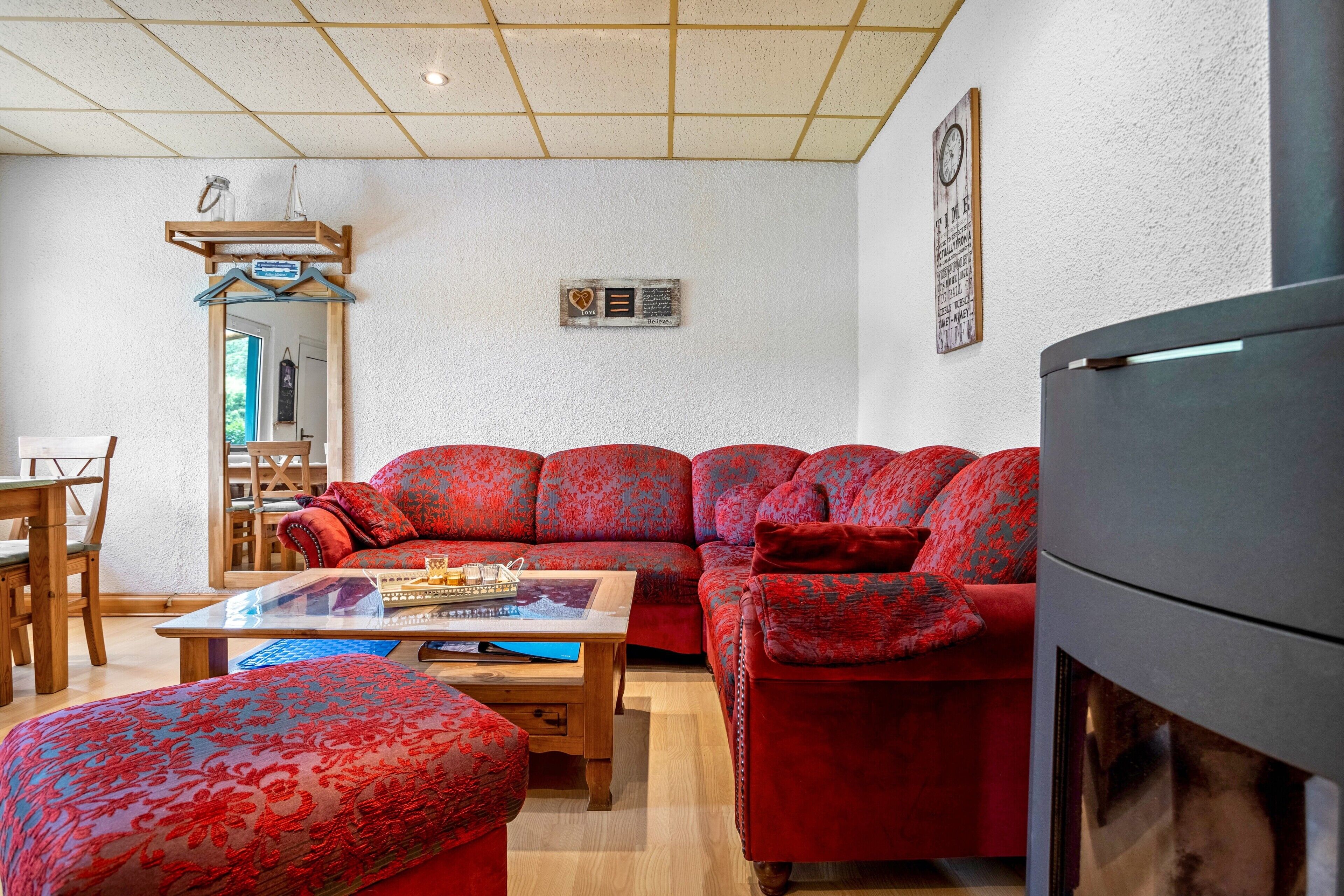 A living room with a red sofa, a coffee table, and a fireplace.