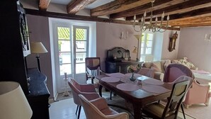 Un comedor con una mesa de madera, sillas y una araña.
