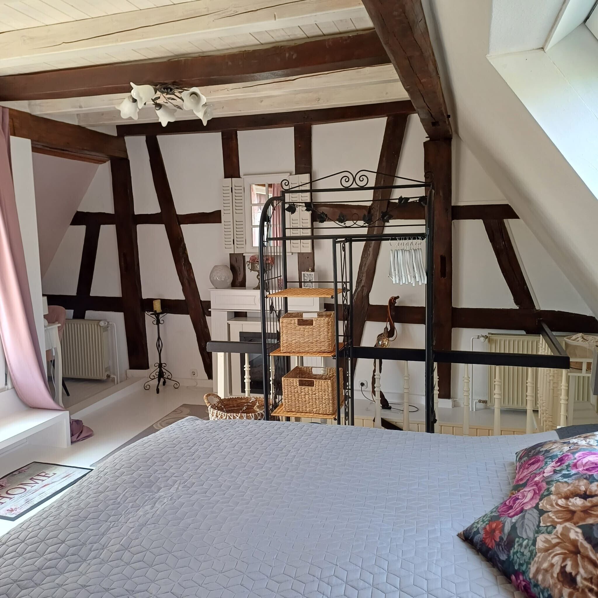 A bedroom with a bed, a hanging chair, a radiator, and a window.