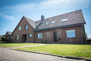 A two-story house with a tiled roof, a brick facade, and a front entrance. - Apartment 'Frieda 4' with Shared Garden, Balcony and Wi-Fi (Meldorf)