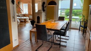 Un comedor con una mesa de madera, sillas, un teléfono negro y un horno de ladrillo.