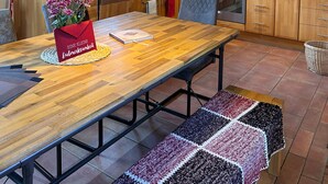 Una cocina con armarios de madera, una mesa de comedor y una lámpara colgante.