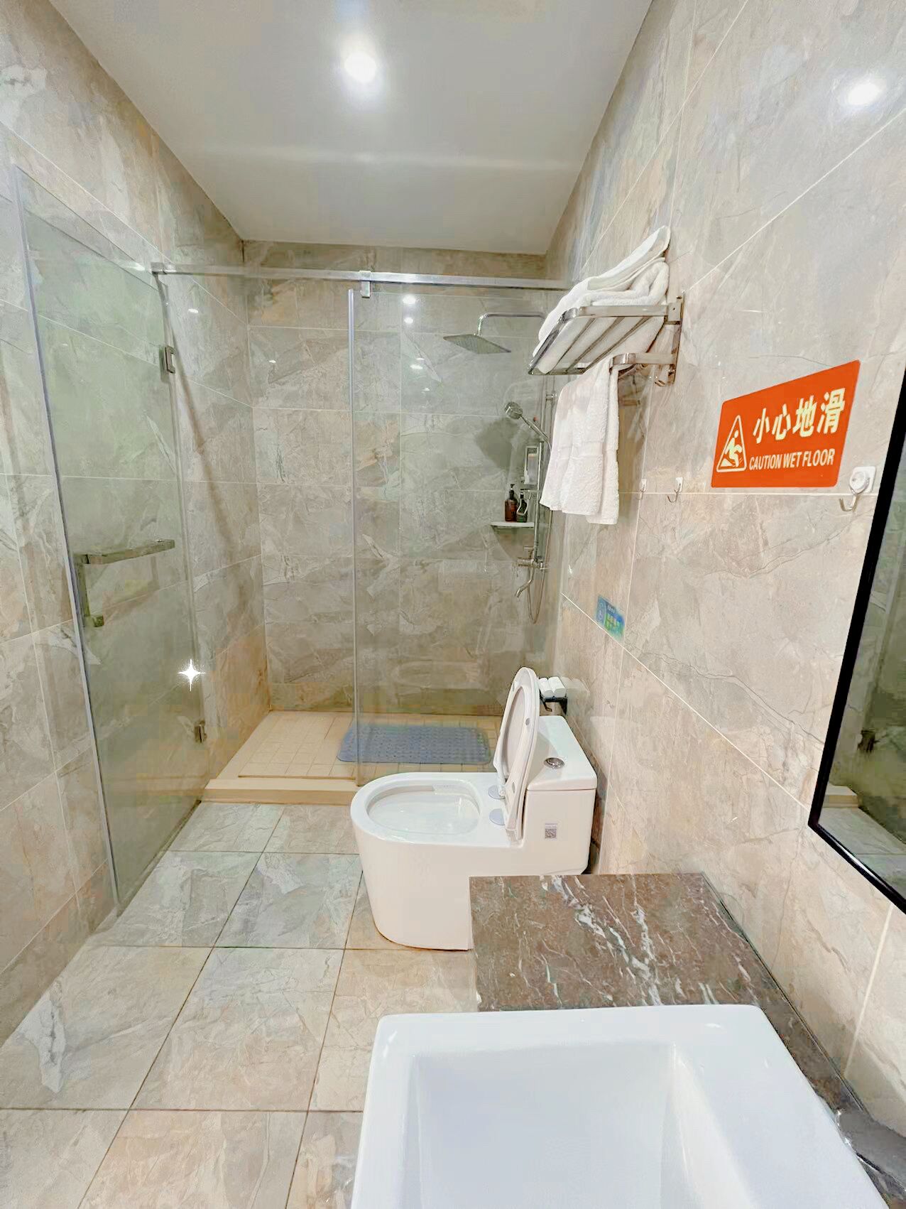 A bathroom with a glass-enclosed shower, a toilet, and a bathtub.