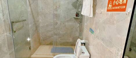 A bathroom with a glass-enclosed shower, a toilet, and a bathtub.